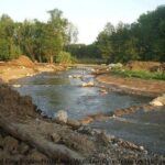 Zu sehen ist das Umgehungsgerinne unterhalb des ehemaligen Wehres in Ochsendorf. Dieser neue Fischpass der Schunter wurde 2007 fertiggestellt und dient der Umgehung des Kraftwerks in Ochsendorf.